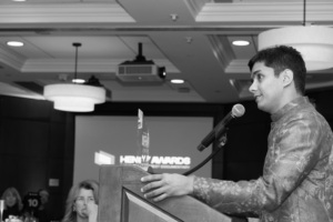 A person standing at a podium and speaking into a microphone.